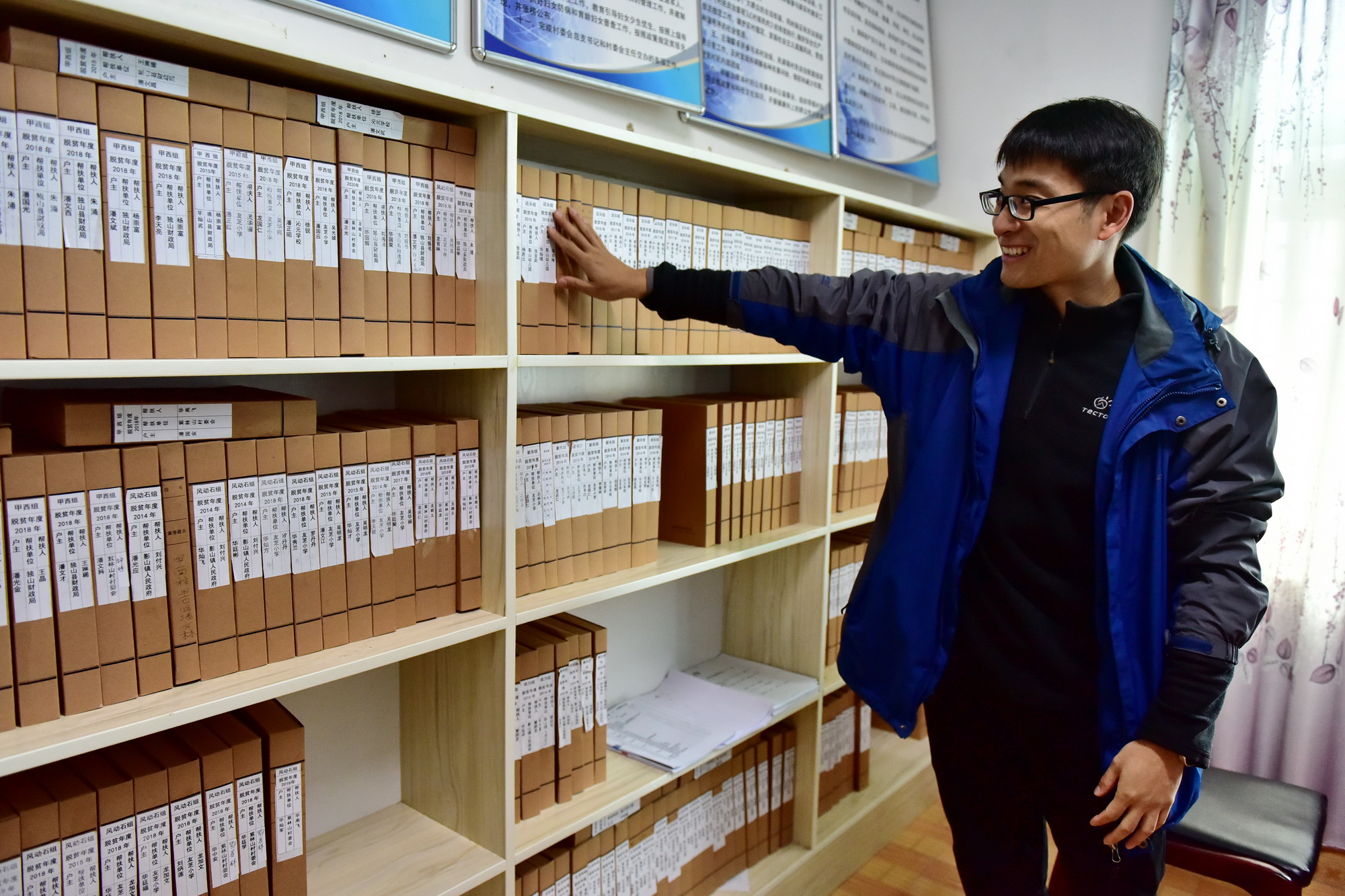 11月13日，贵州省独山县紫林山村挂职第一书记曲佳向记者们介绍贫困户建档立卡情况。摄影/章轲