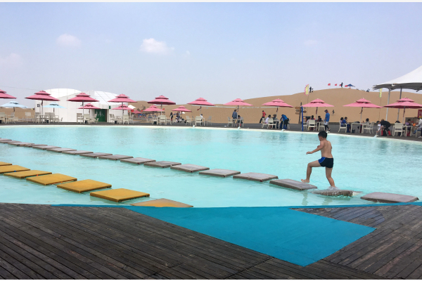 中国旅游业发展迅速。图为响沙湾景区的沙漠泳池。新华社图