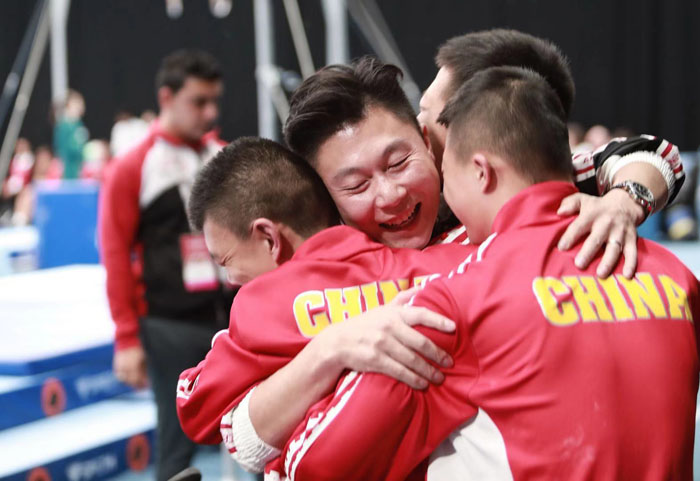 赛场边,李小鹏与中国特奥体操运动员们拥抱。 摄影/罗四维
