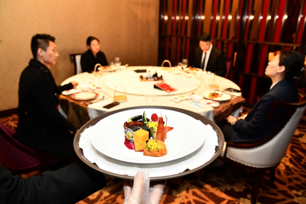 中国餐饮消费经历低谷后正在逐步复苏。图为3月26日，在山东舜和国际酒店，工作人员为客人上分餐。新华社发