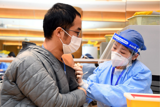 2月22日，在北京市海淀区中关村软件园二期一家企业内的临时接种点，医护人员为企业员工接种新冠疫苗。新华社图。