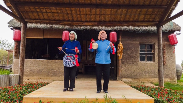 小岗村“当年农家”景区里，75岁的邓凡兰和72岁的陈玉芝姑嫂二人在演奏凤阳花鼓。 吴军/摄