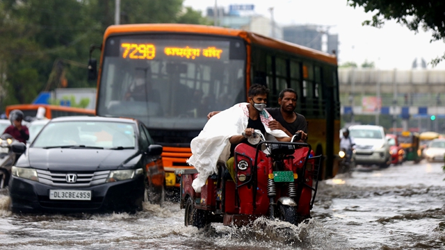 印度今年的季风雨季遭遇多轮强降雨，雨季过后近期的降水也超过往年。图为7月14日，车辆在印度新德里积水的街道上行进。新华社