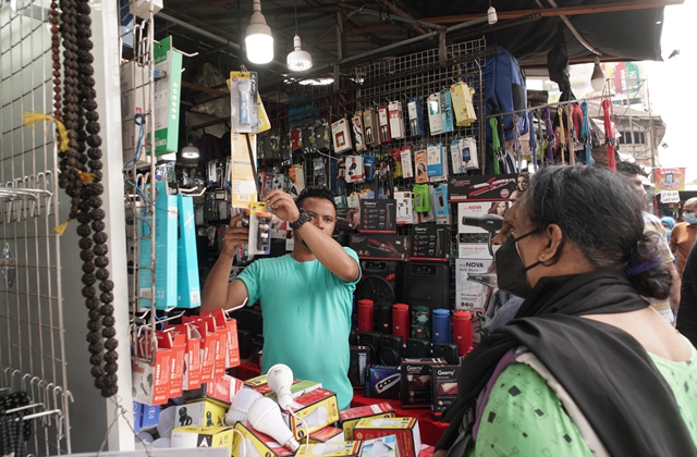 4月2日，在斯里兰卡科伦坡一家市场，商贩向顾客展示充电式手电筒。由于供电紧张，可充电手电筒受到欢迎。新华社资料