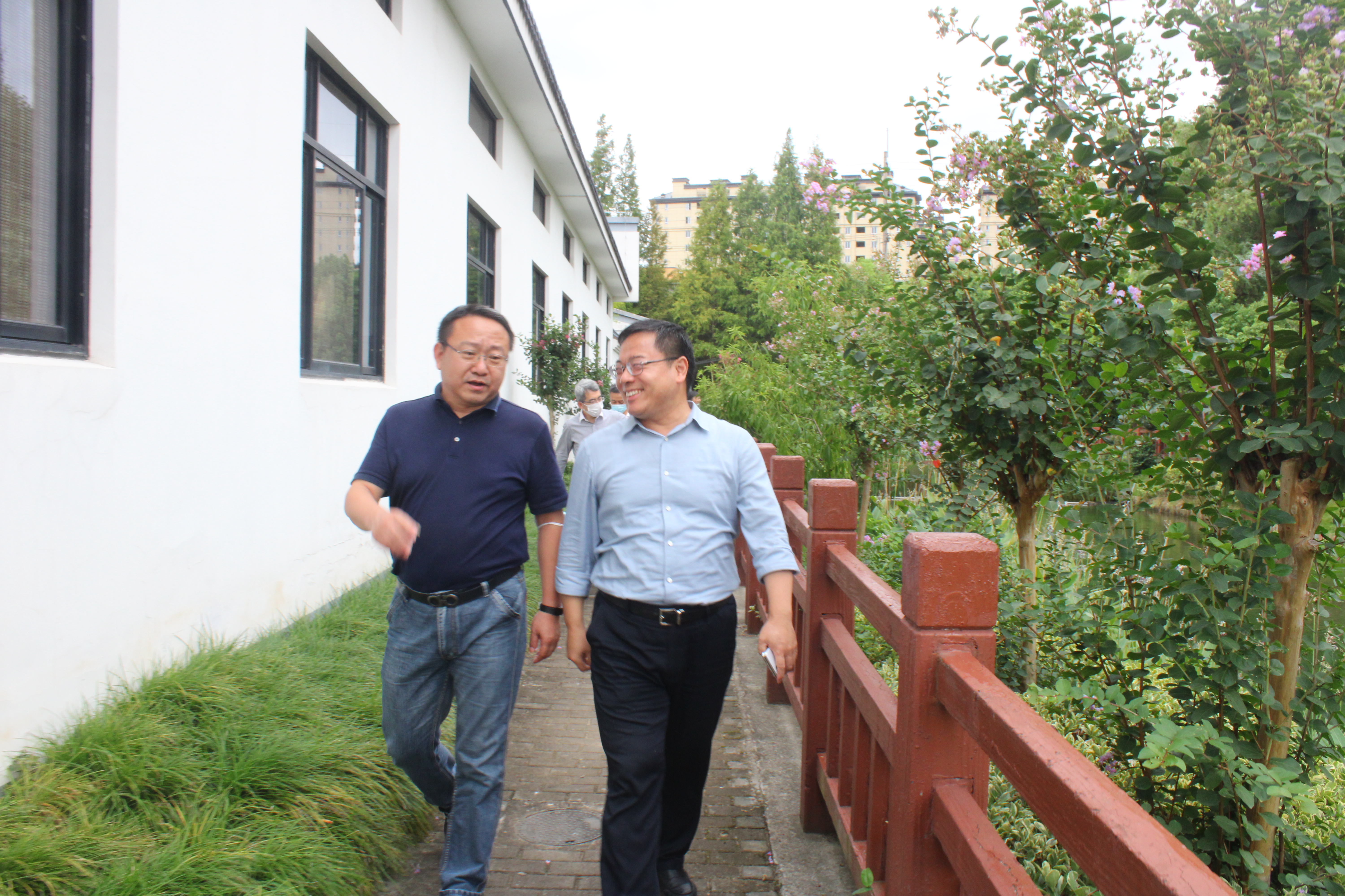 市水务局副局长阮仁良（右）和闵行区水务局局长陆彬文在考察吴泾镇和平村区域水系时交流治水效果