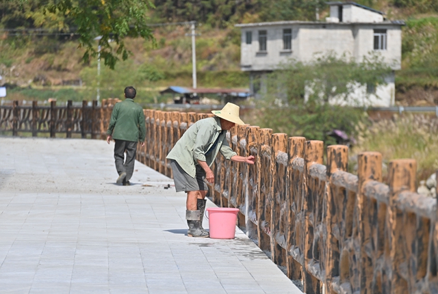  在广西融水苗族自治县香粉乡雨卜村，工人在清洗刚刚建好的亲水平台栏杆。