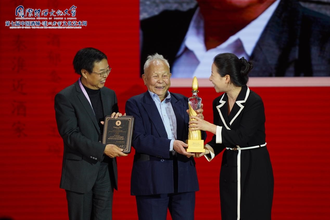 1573金沙诗歌奖评委会主席、诗歌评论家、四川大学文学与新闻学院院长李怡（左），泸州老窖集团党委委员、元景达食品有限公司董事长兼总经理潘丽娜（右）共同为谢冕先生（中）颁发2023年度“1573金沙诗歌奖·诗歌评论特别贡献奖”