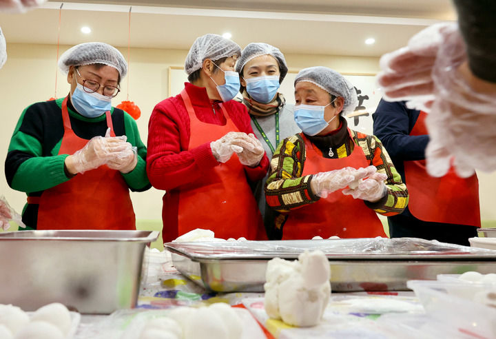 2月12日，社区居民在黄浦区老西门街道“厢遇85”社区长者食堂包汤圆，迎接元宵节。新华社记者 方喆 摄
