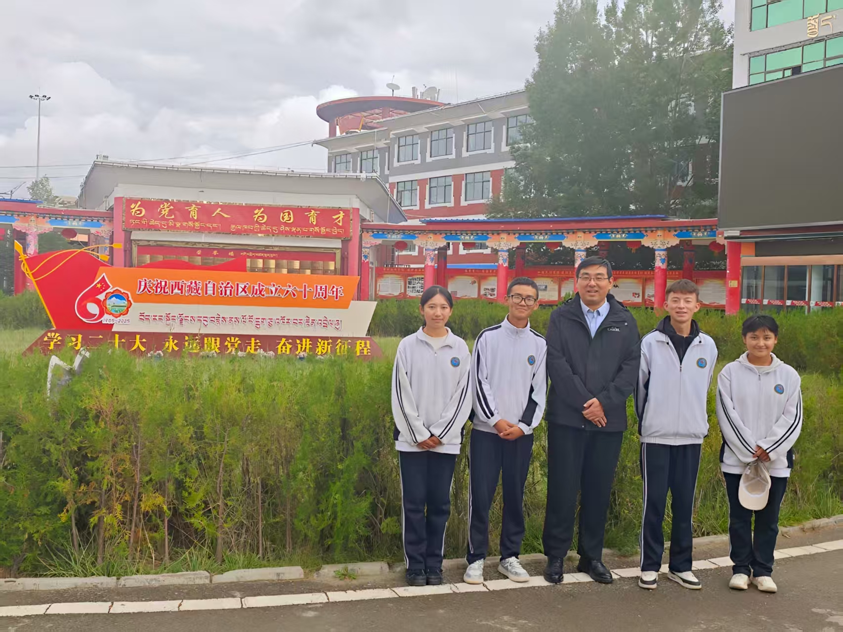 日喀则上海实验学校副校长马云豪和当地学子在西藏自治区六十周年华诞期间合影留念