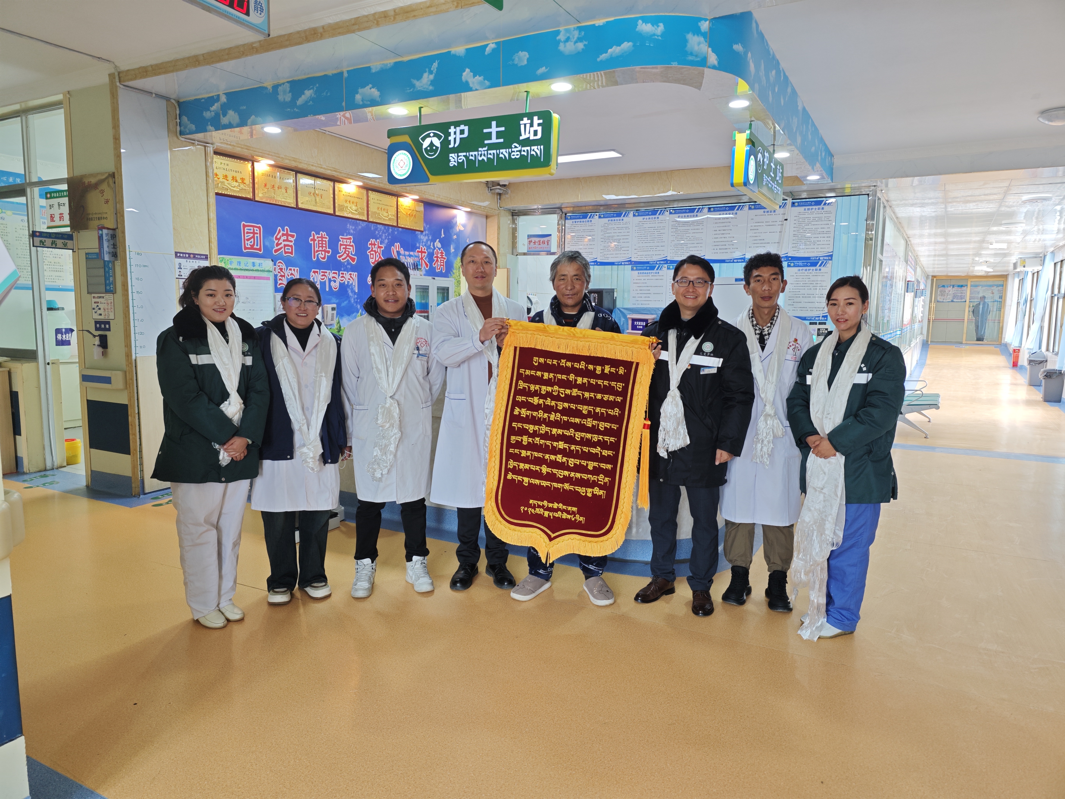 上海市第八人民医院普外科援藏医生黄雄（左四），在当地接受藏族同胞的锦旗。