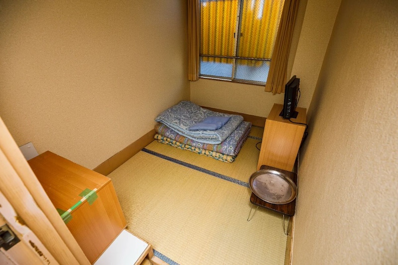 白根宾馆内三叠大的房间。这个单人间里除了被褥，只有电视、桌子和置物架。