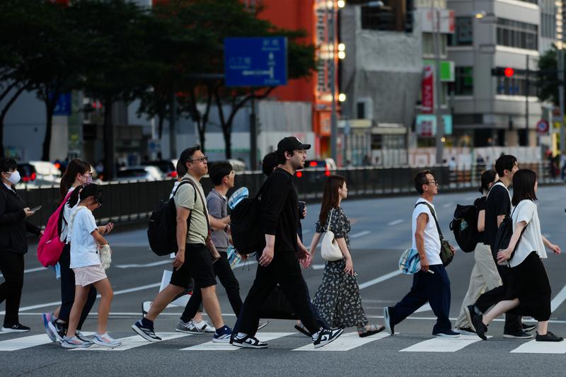 8月14日，在日本东京，人们穿过马路。新华社