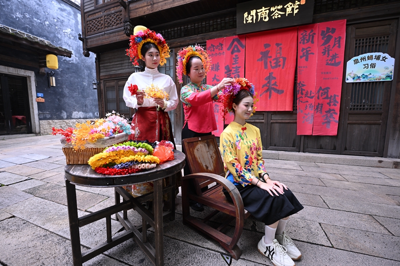 黄丽泳（中）在2025年“文化和自然遗产日”福建非遗主会场活动中展示泉州蟳埔女簪花围    新华社图