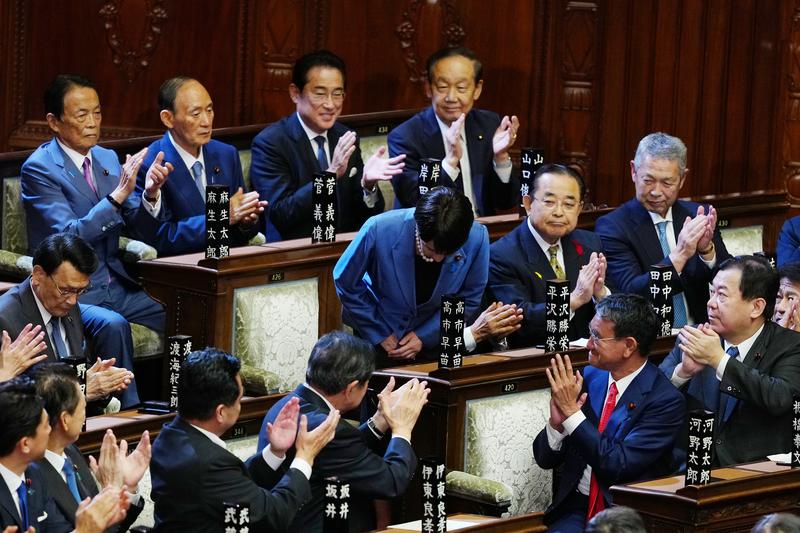 10月21日，在日本东京，自民党总裁高市早苗（中）在临时国会众议院首相指名选举中胜出后起身致谢。新华社