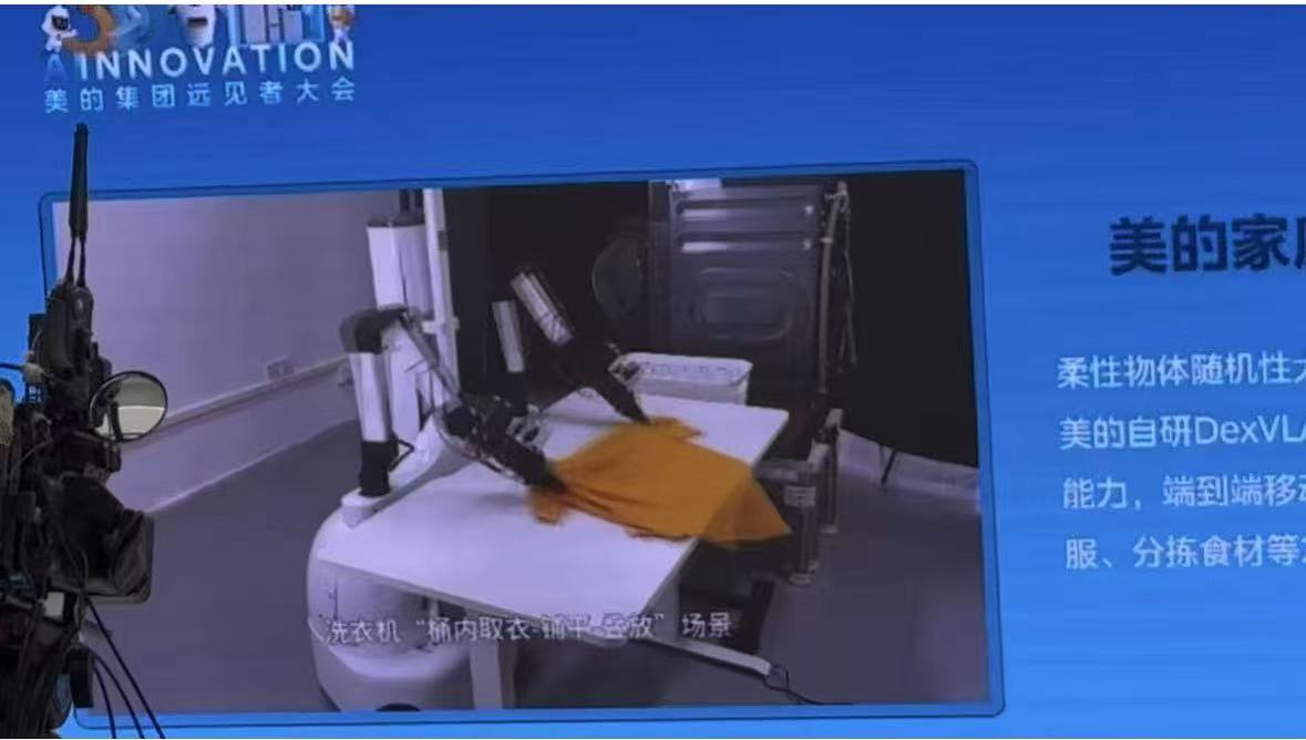 美的集团AI研究院院长徐翼在演讲中播放机器人折叠衣服的视频截图。拍摄/第一财经记者王珍