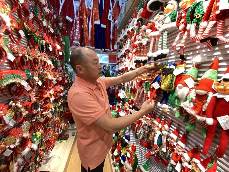 在浙江义乌国际商贸城，经营户在店铺内整理圣诞商品。新华社资料图