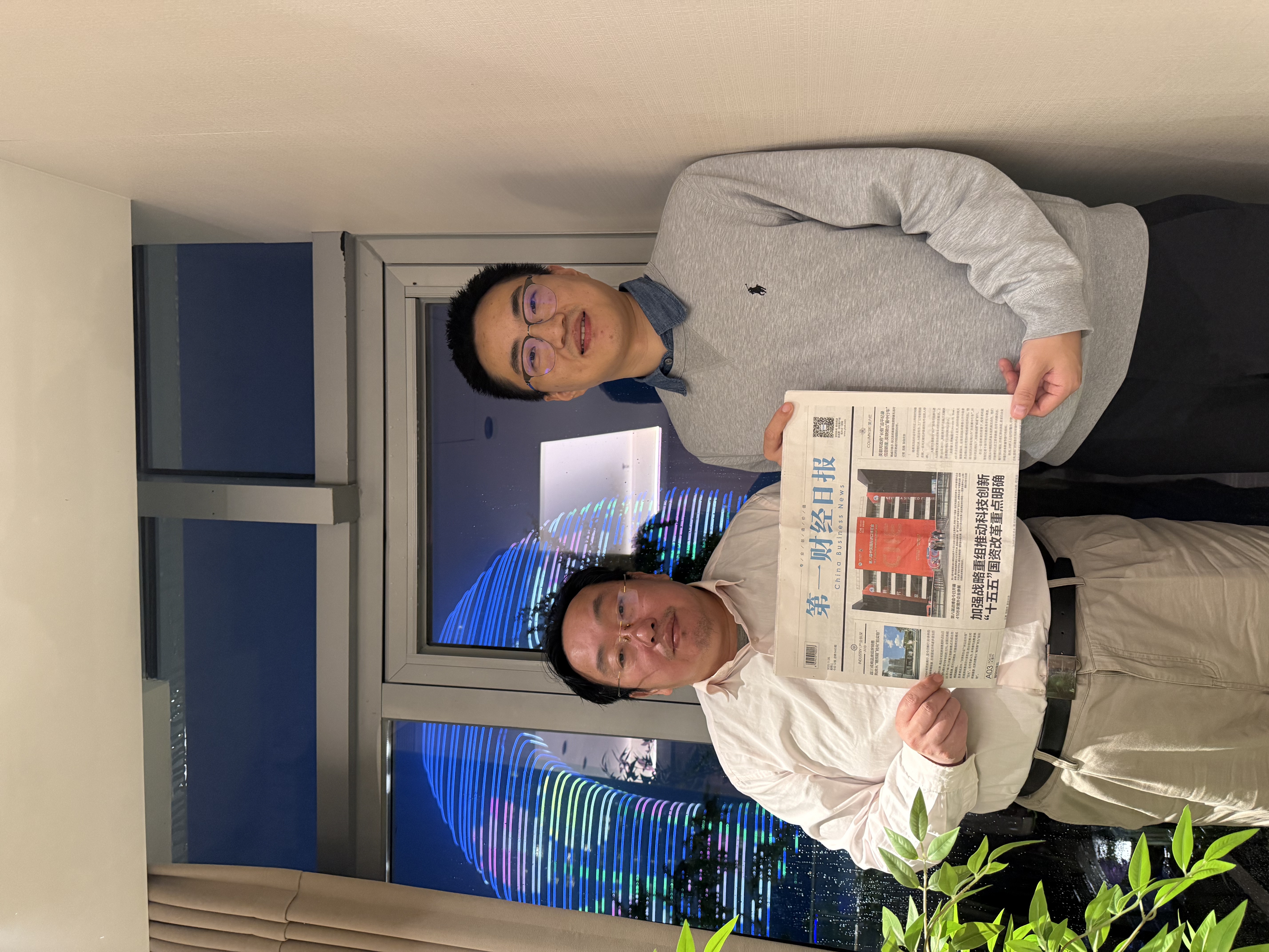 作者（左）和一财读者、上海社科院校友沈路人，在南太湖新区交流一财主题报道品读心得。