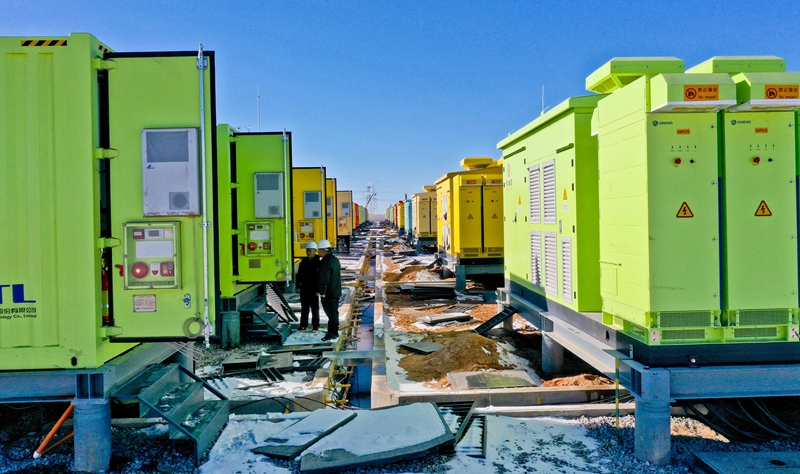 2025年11月24日 ，甘肃省张掖市临泽县北部滩新能源产业园内，300MW/1200MWh独立储能电站的储能电池集装仓项目施工现场，工作人员正在顶风冒雪进行输送电设备的调试和检测。  视觉中国图