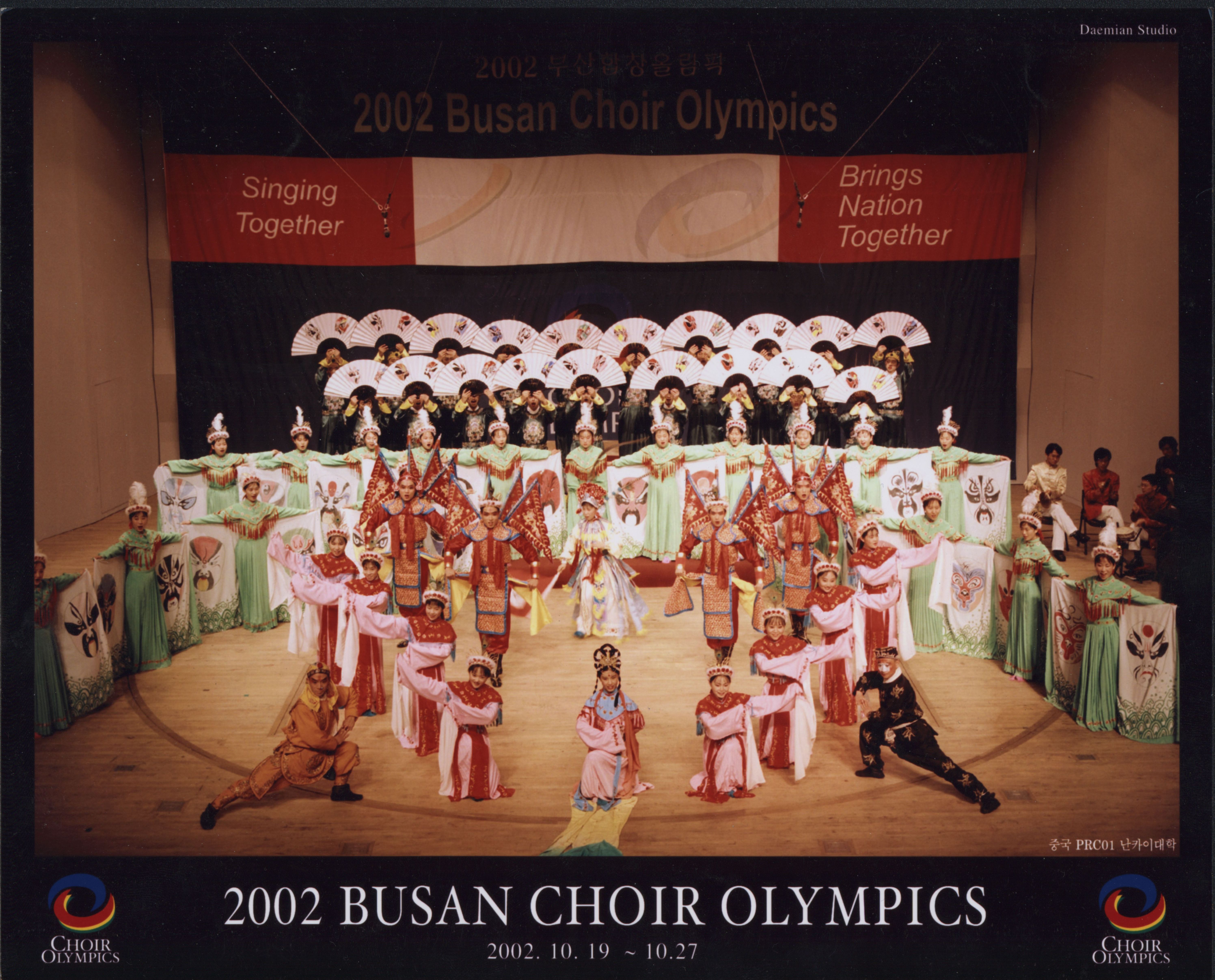 图为南开大学学生合唱团参加2002年韩国釜山奥林匹克国际合唱比赛，演唱的一首京剧有表演合唱《盛世梨园情》获得金奖冠军，为祖国升起国旗奏响国歌，同时也在国际合唱舞台上展示传播了中国传统文化和艺术。