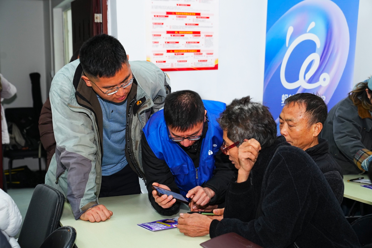 在蓝马甲志愿者的帮助下，村医们认真学习如何使用蚂蚁阿福app。