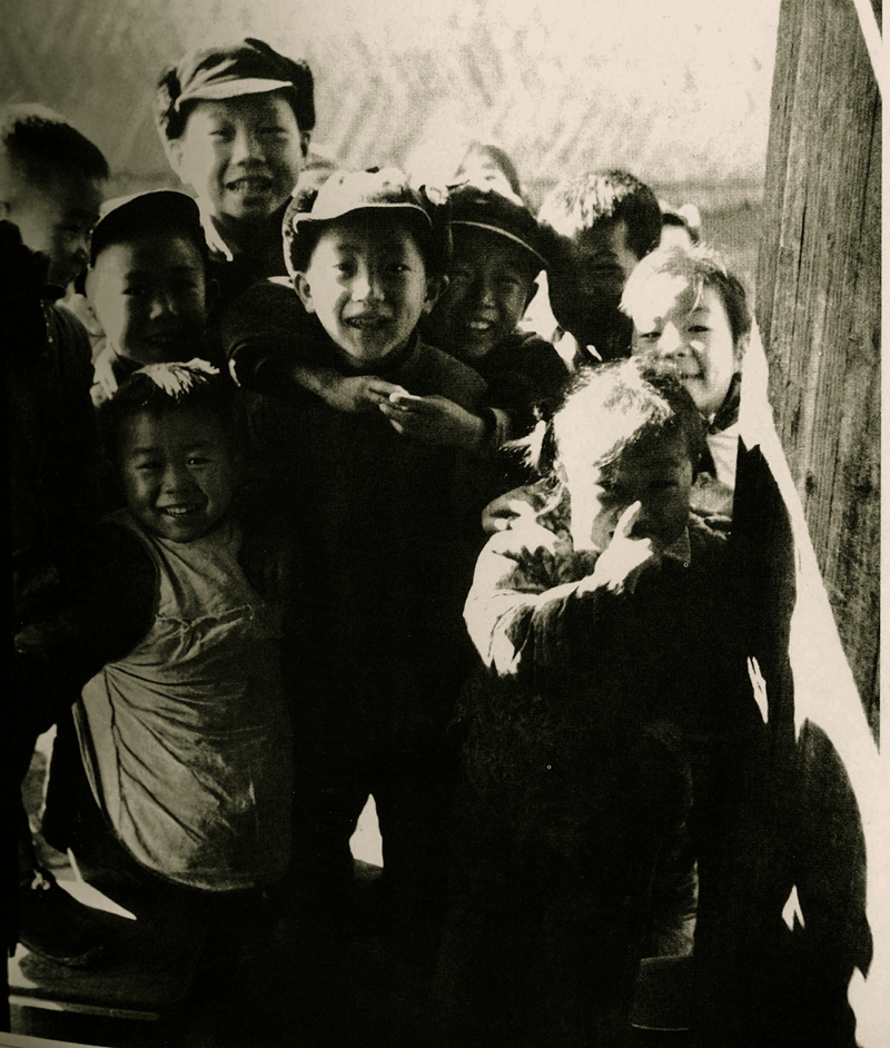 1963年春节 ，中山公园附近的弄堂里，一群好奇的孩童围着偶遇的摄影师，喊着“叔叔给我们拍照”（薛宝其 摄）