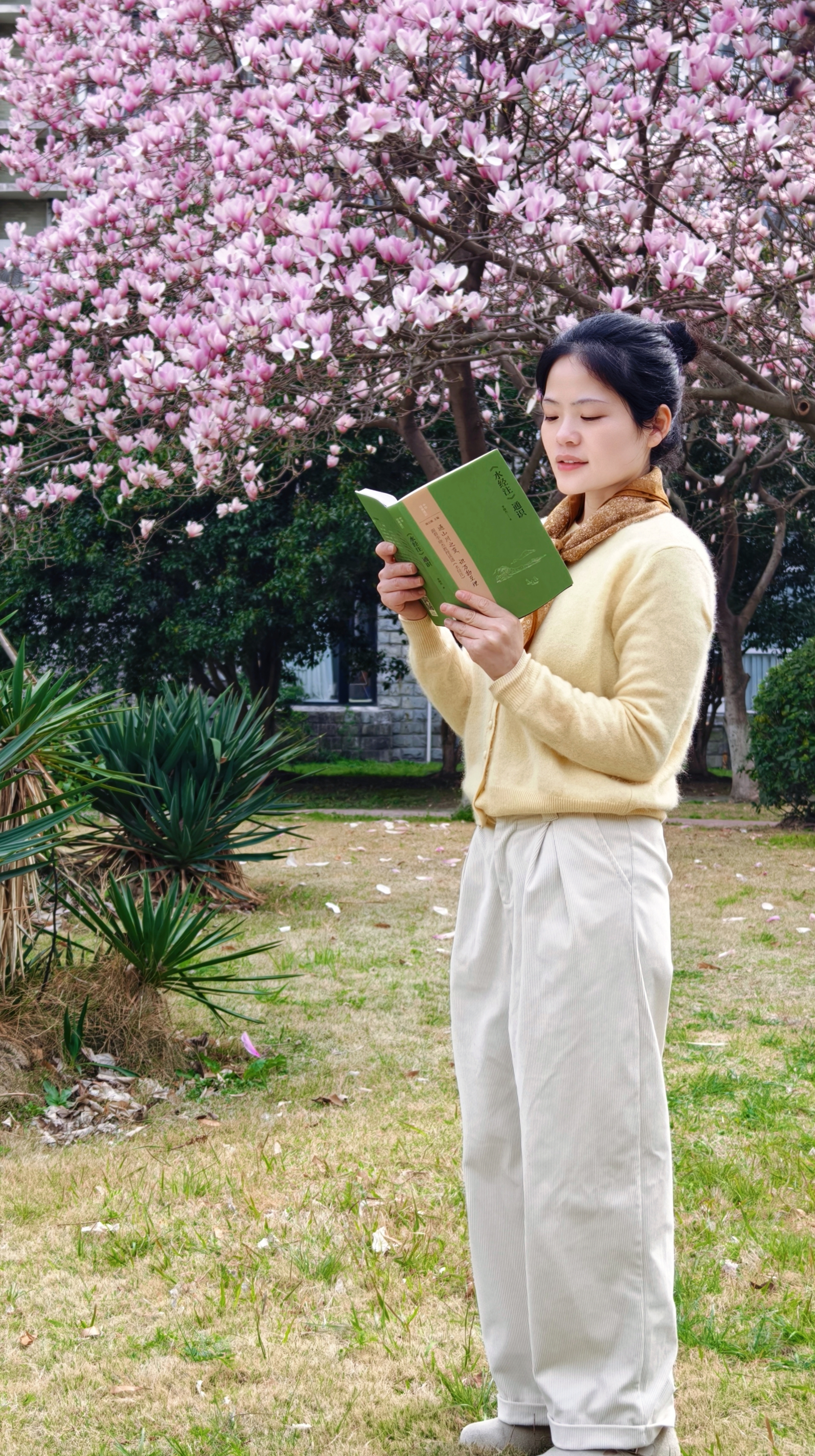 华东理工大学附中青年地理教师高露在校园紫玉兰树下品读李晓杰教授专著