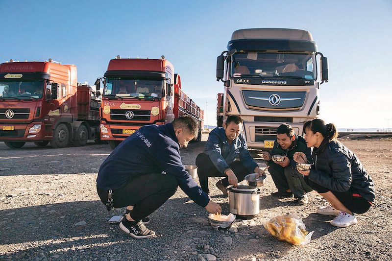几辆卡车的司机凑在一起吃早饭，高原地区熬粥也得用高压锅（蔡小川摄 出版社供图）