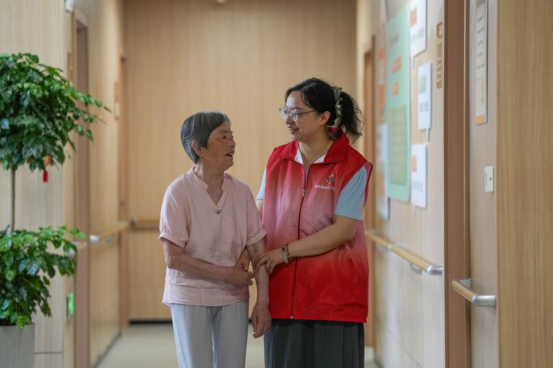 江苏泰州一街道养老服务中心老年公寓,社区志愿者陪着居住在这里的老年人散步、聊天。新华社