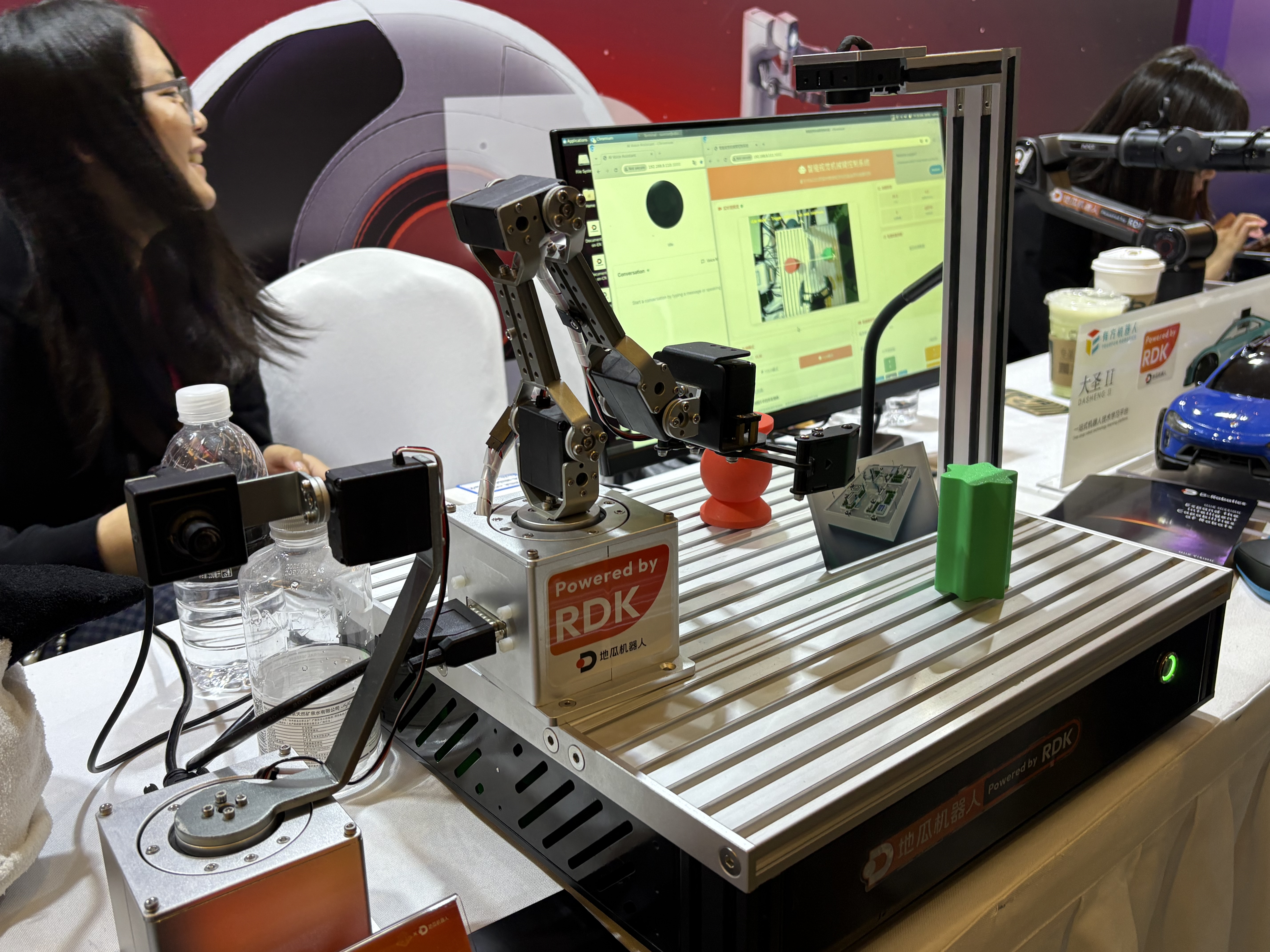 ROSConChina 2025大会上，开发者正在围观机器人硬件操作。图片来源：乔心怡