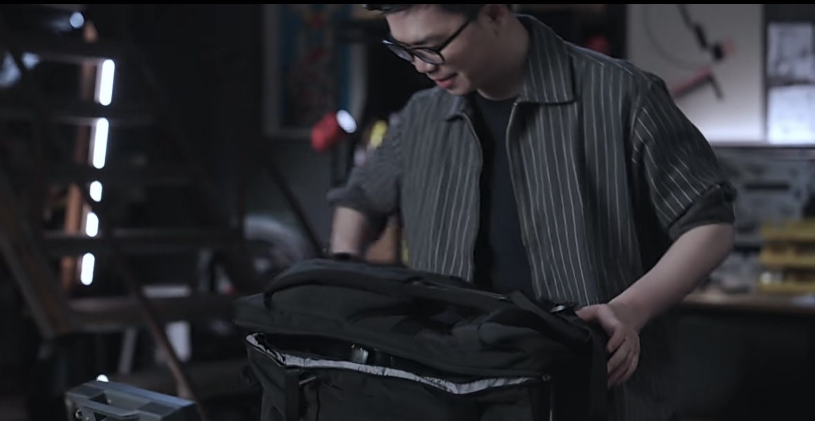 “稚晖君”打开背包，拿出机器人。图片来源：视频截图。